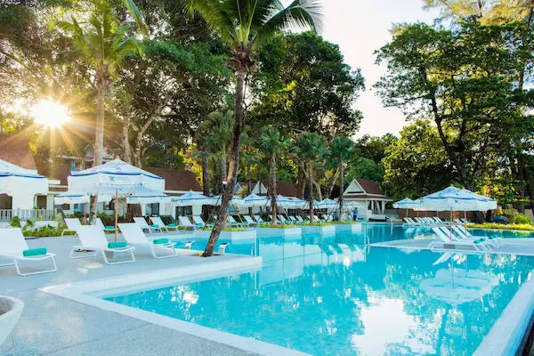 Lækkert poolområde omgivet af palmer og andre grønne planter på Khaolak Emerald Beach Resort & Spa,