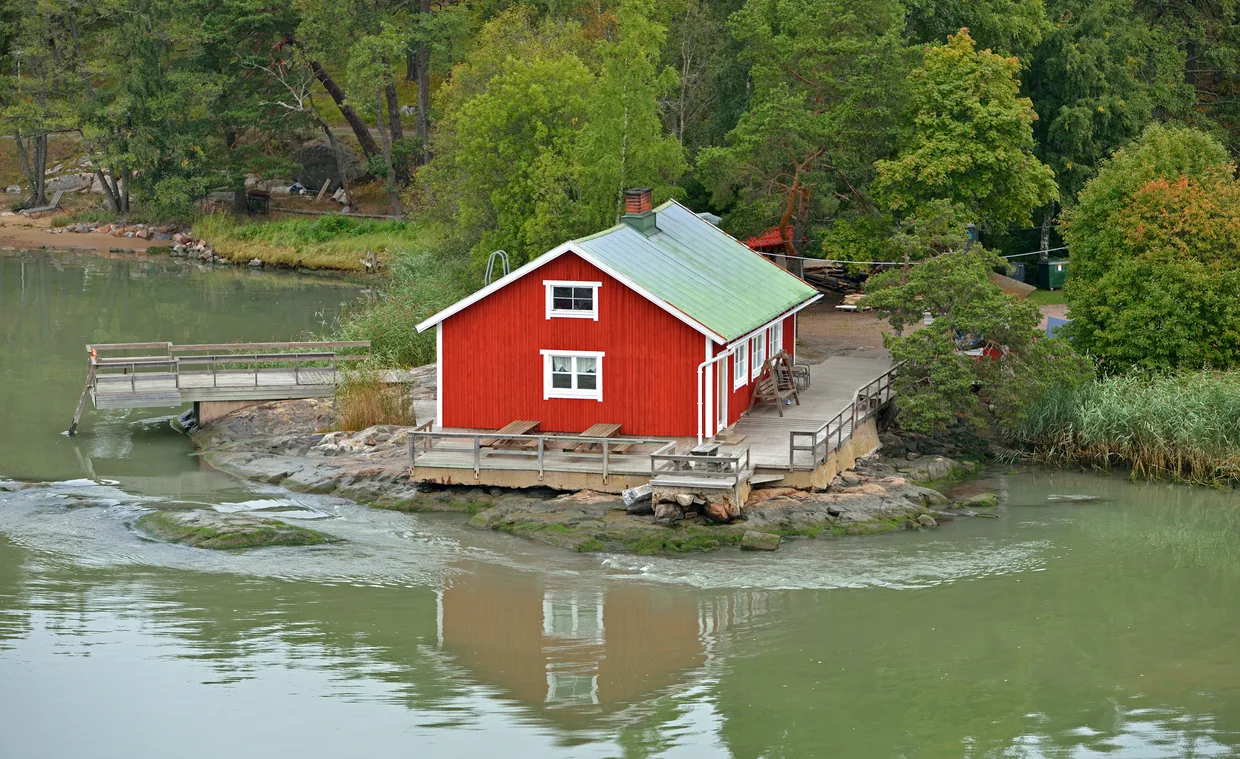 Rødt træhus på klipperne ved havet i skærgården ud for Turku i Finland