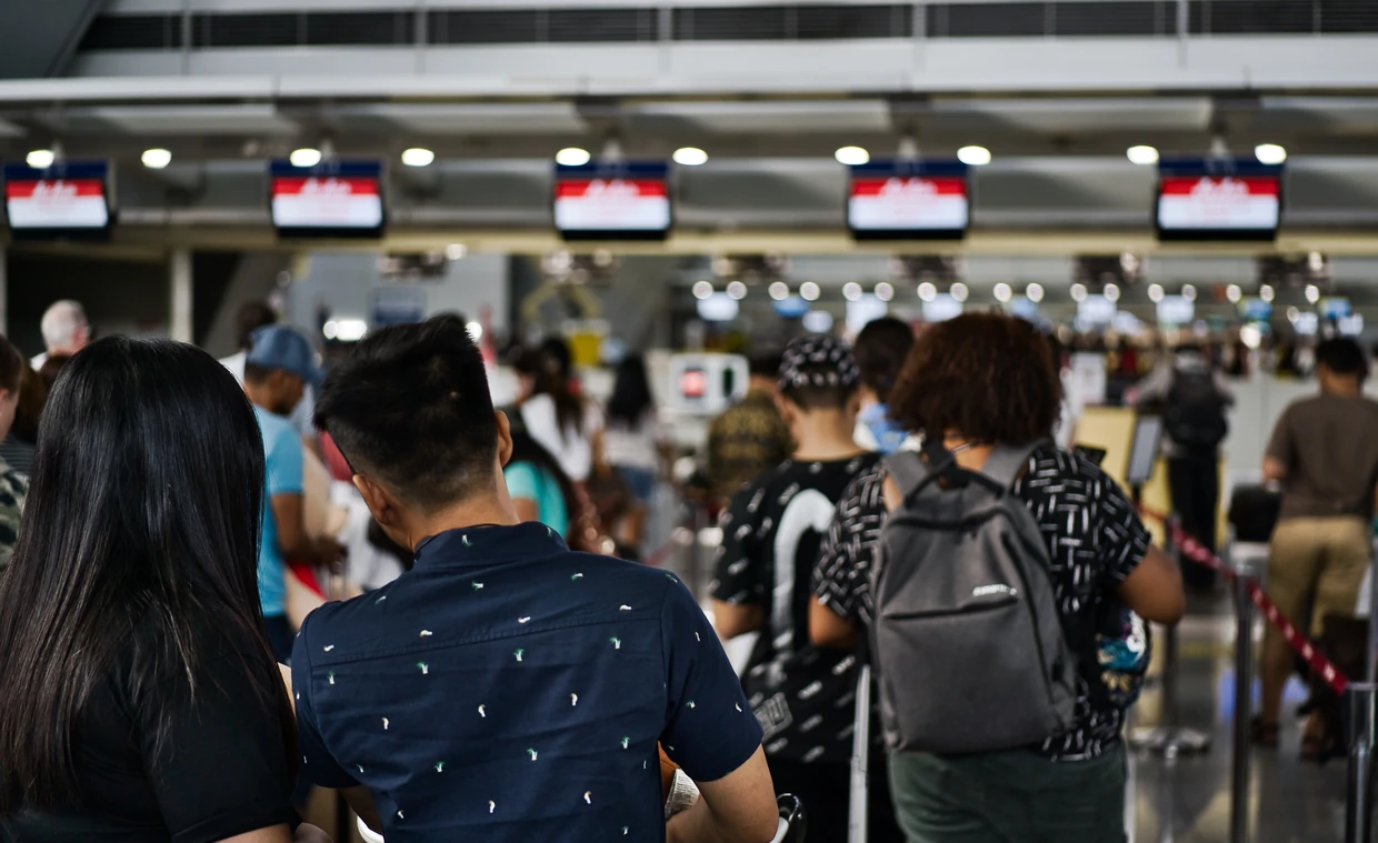 Rejsende står i lang kø i en lufthavnsterminal